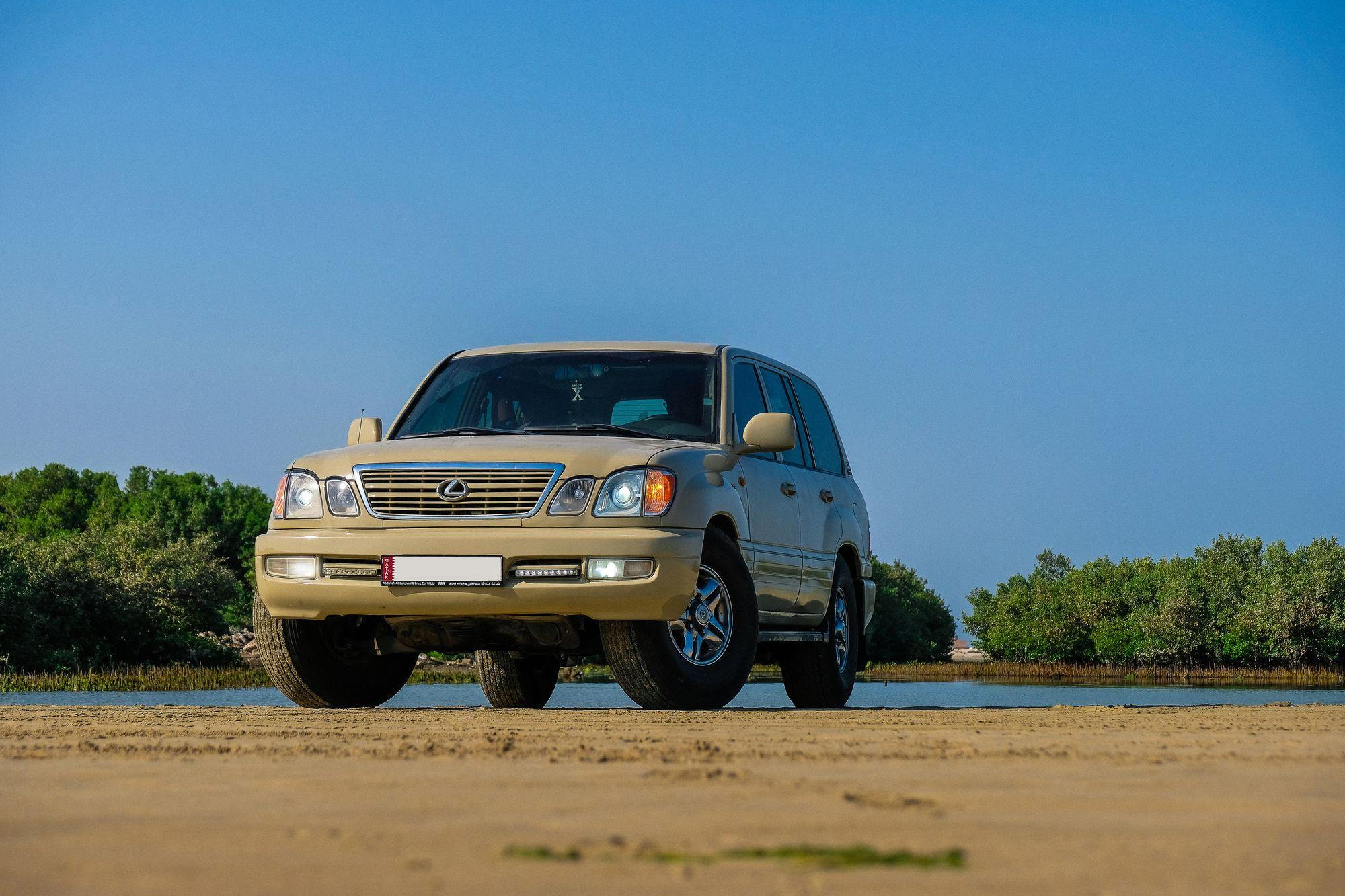 Gold Lexus LX on open ground